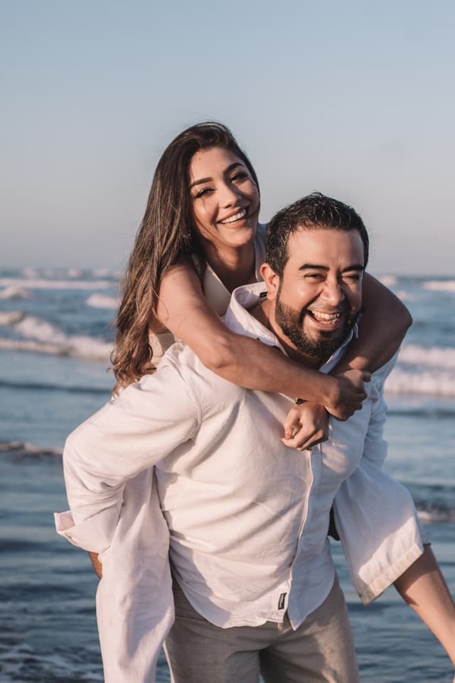 Jordan and Morgan on the beach, laughing together.